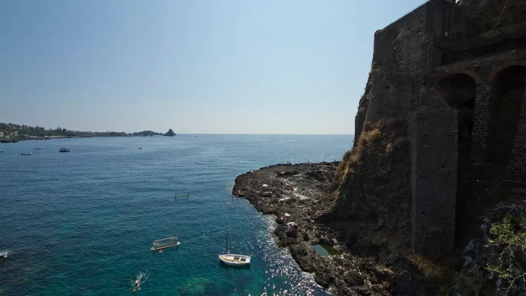 Il castello di Aci Castello sul mare, con i faraglioni sullo sfondo