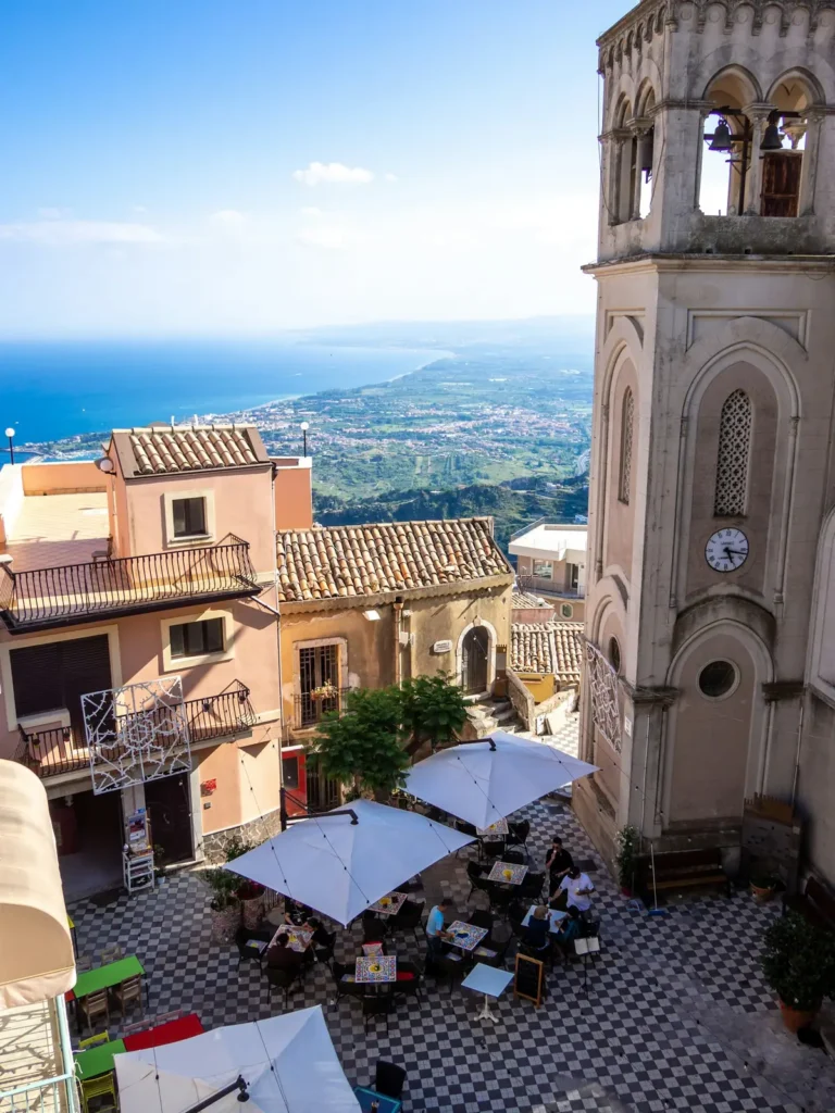 Un borgo siciliano con campanile e vista sul mare