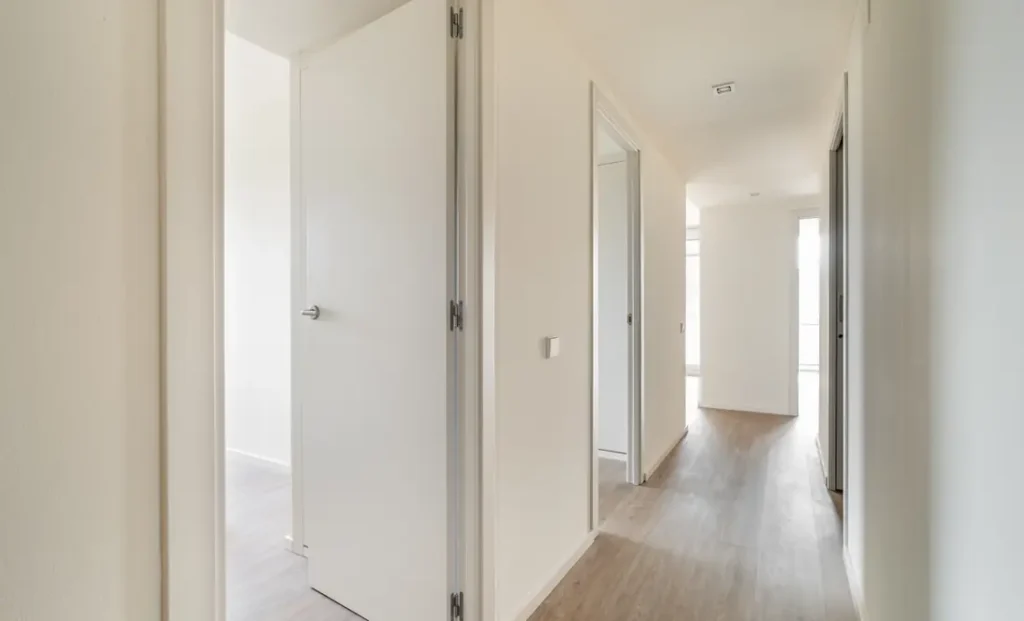 Interno luminoso di un appartamento con parquet e porte bianche